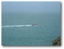 The Padstow Lifeboat patrols Port Quin Bay as viewed from Doyden Castle